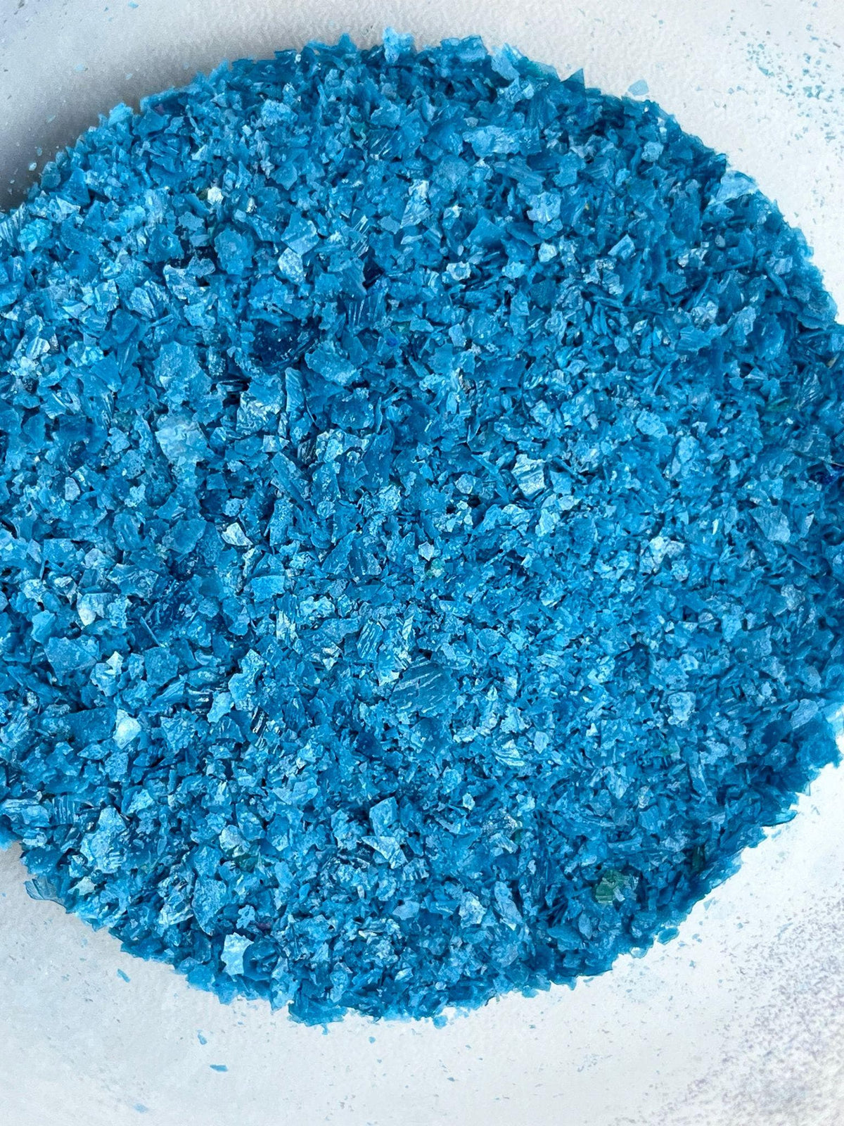 Blue edible wafer paper glitter flakes shown close up for cake and dessert decoration.