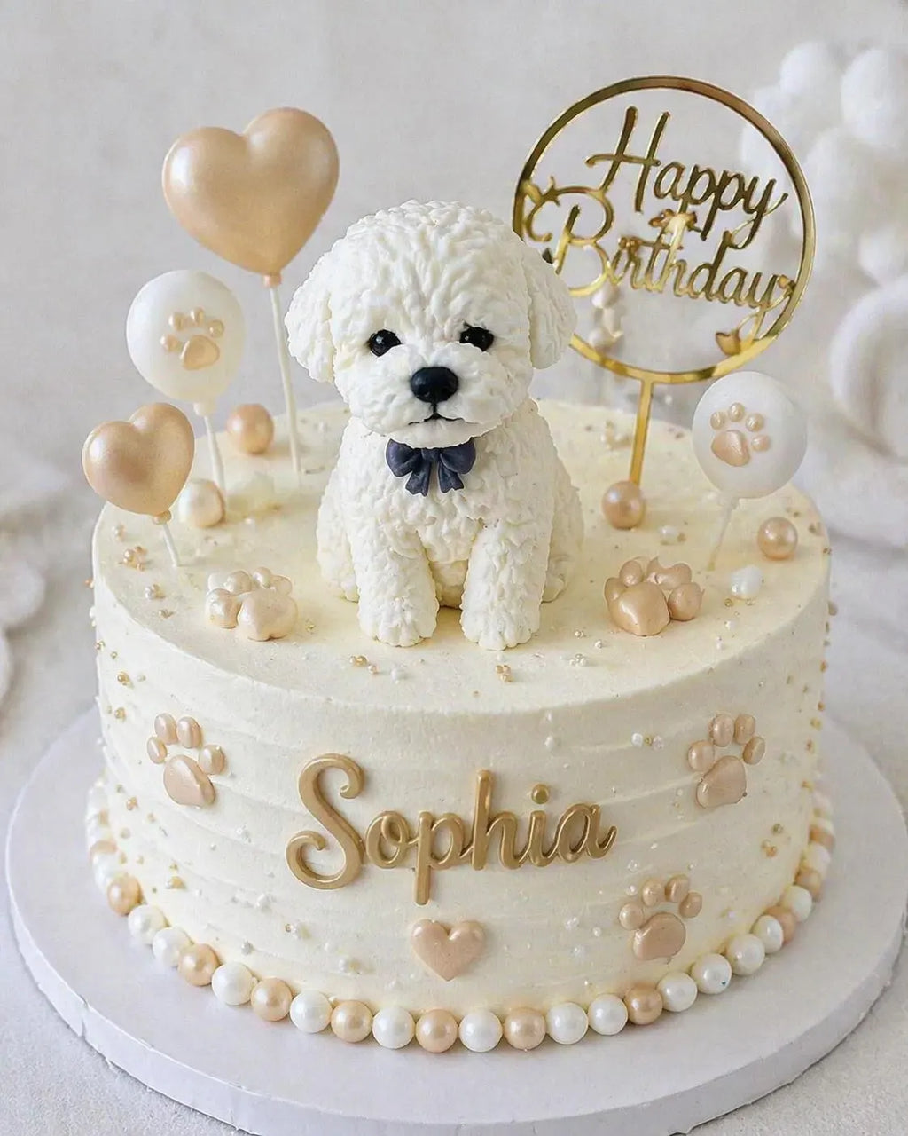 White edible fondant dog cake topper with textured fur and a dark bow, displayed on a birthday cake.