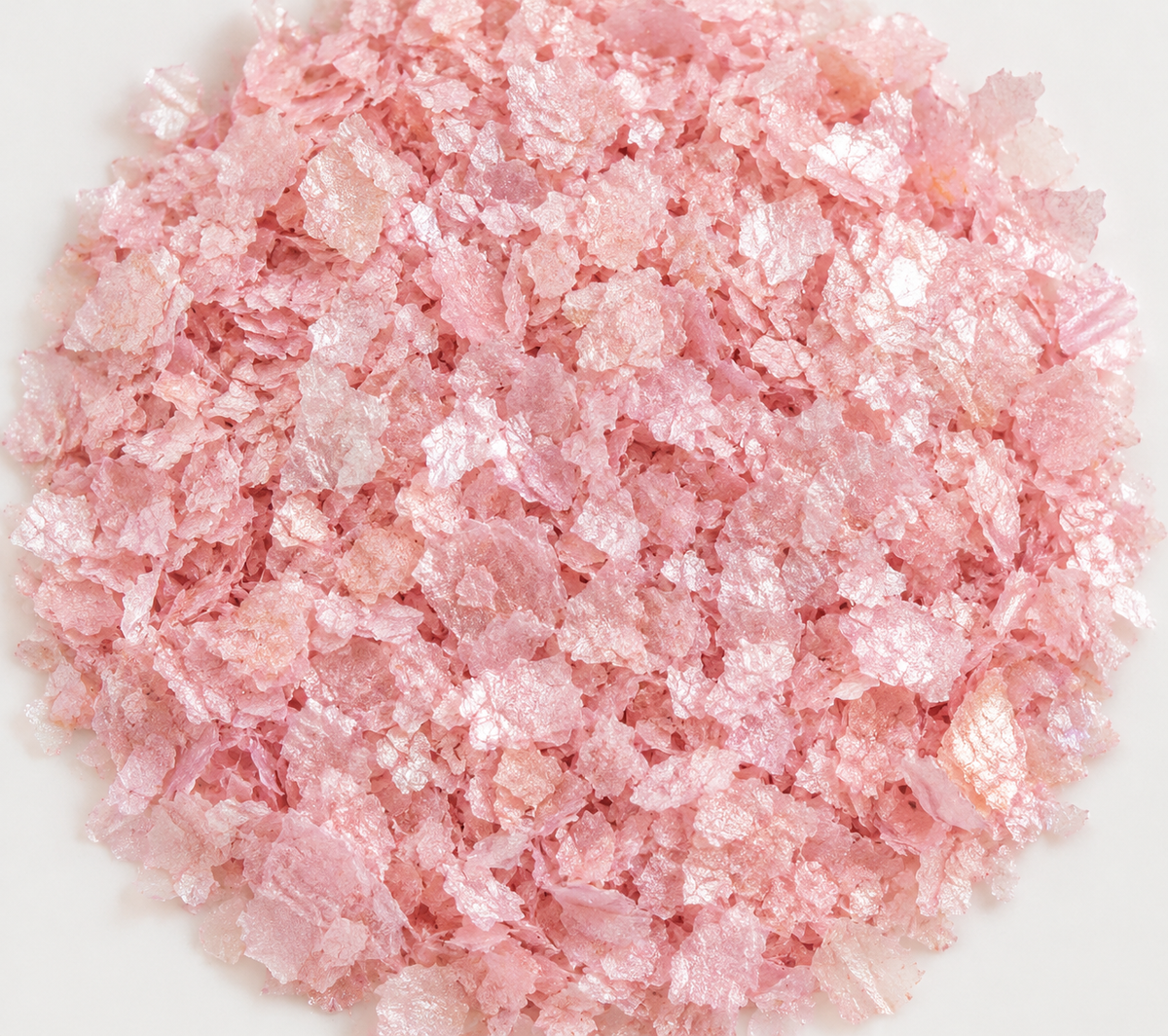 Light pink edible wafer paper glitter flakes shown close up for cake and dessert decoration.