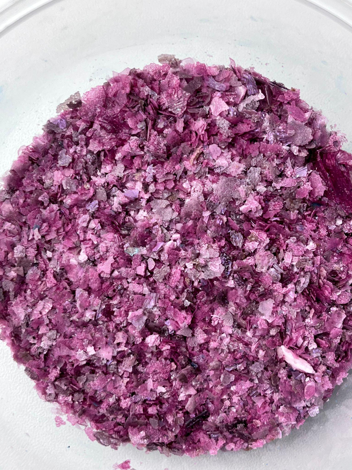 Pink edible wafer paper glitter flakes shown close up for cake and dessert decoration.