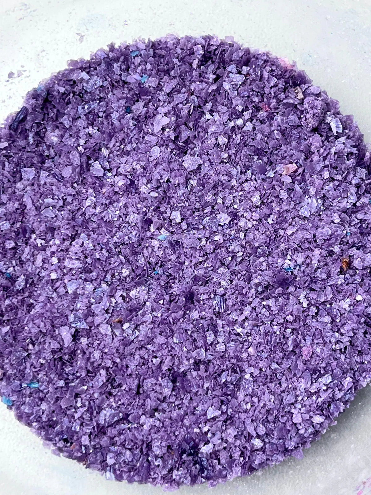 Purple edible wafer paper glitter flakes shown close up for cake and dessert decoration.