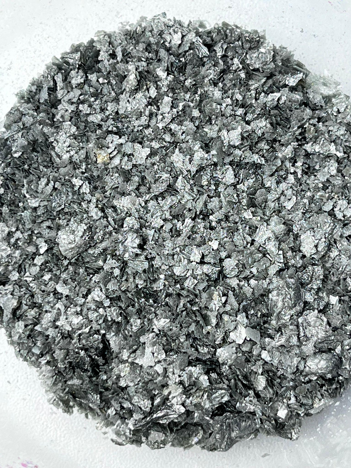 Silver edible wafer paper glitter flakes shown close up for cake and dessert decoration.