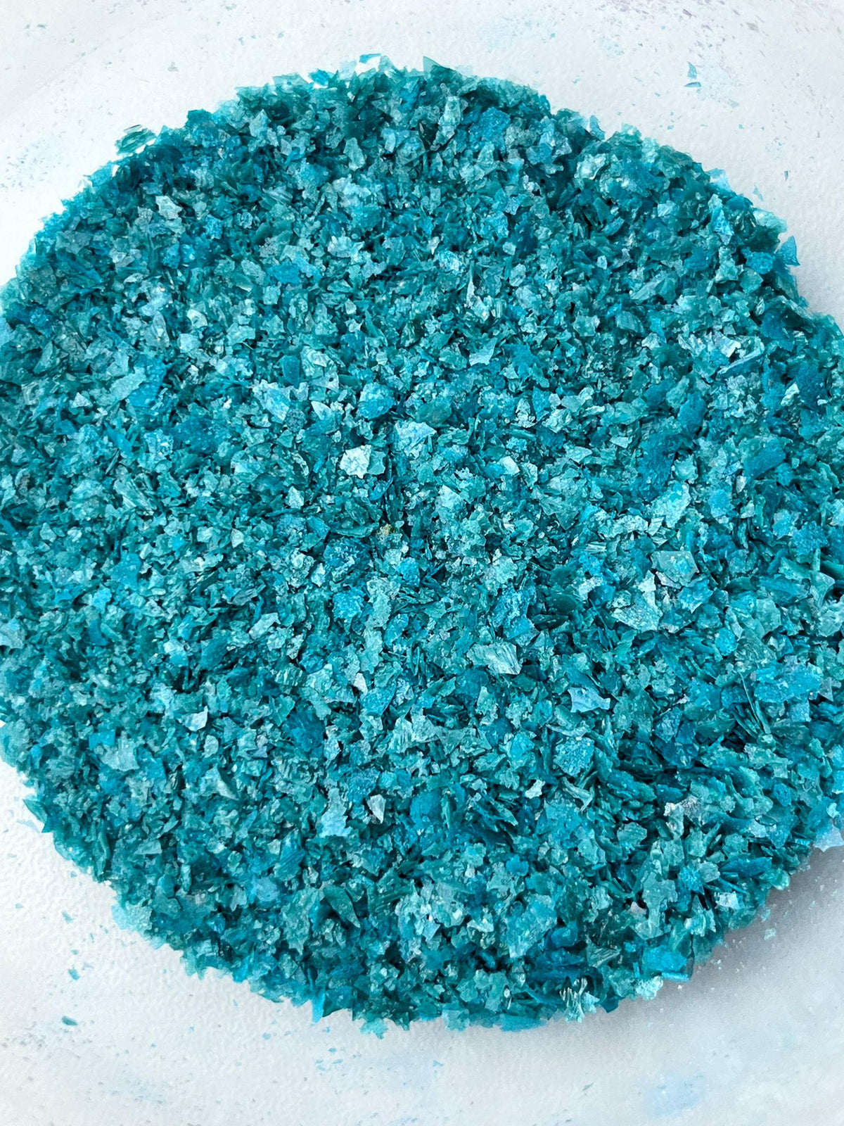 Turquoise edible wafer paper glitter flakes shown close up for cake and dessert decoration.